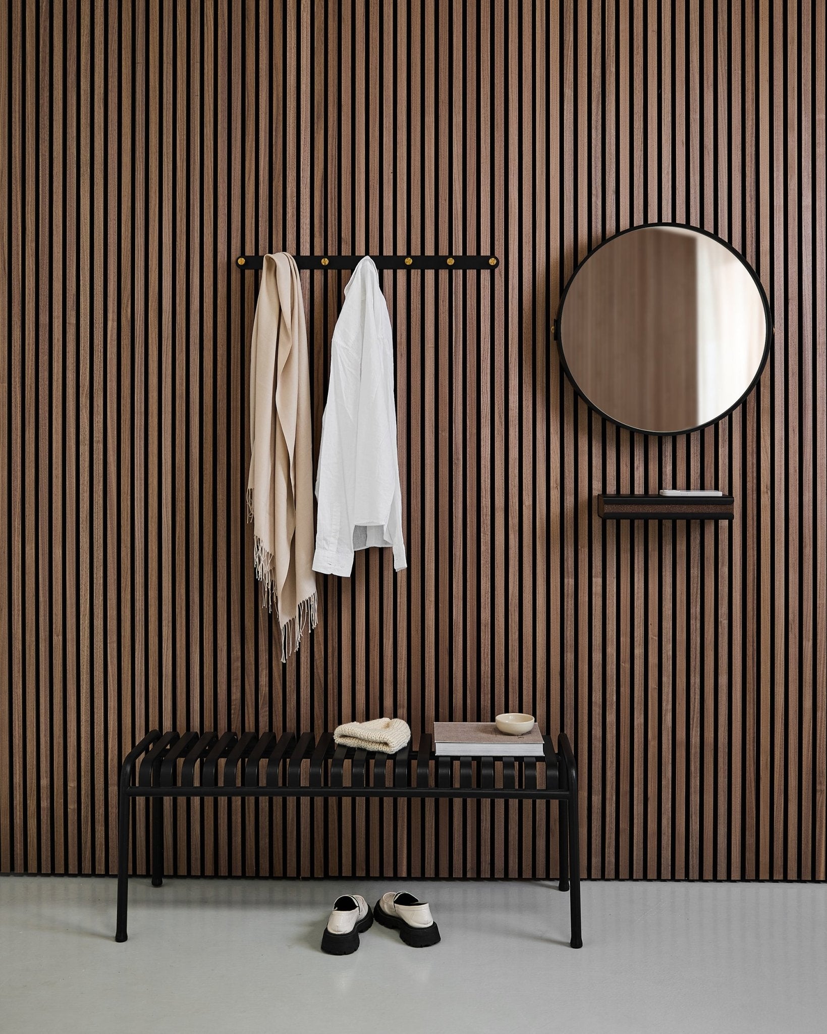 Entrée minimaliste avec un WoodUpp Linn | Mirror en Black Oak, panneau mural acoustique à lattes nordique, banc, étagère, manteau et écharpe suspendus, et chaussures au sol.
